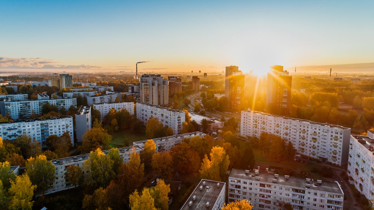 Crafting Captivating Headlines: Your awesome post title goes here Aerial view of a cityscape at sunrise with autumn foliage and modern buildings.